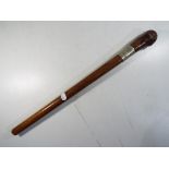 A wooden ceremonial club with white metal mount marked 1884, approximately 44 cm (l).