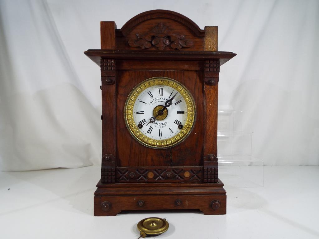 An oak cased table alarm clock by Fattorini and Sons, Bradford,