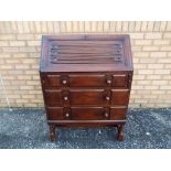 An oak cased writing bureau with hinged lid opening to reveal pigeon hole interior over three