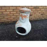 A terracotta stone lidded Chimenea on wrought stand approx 70cm (h)