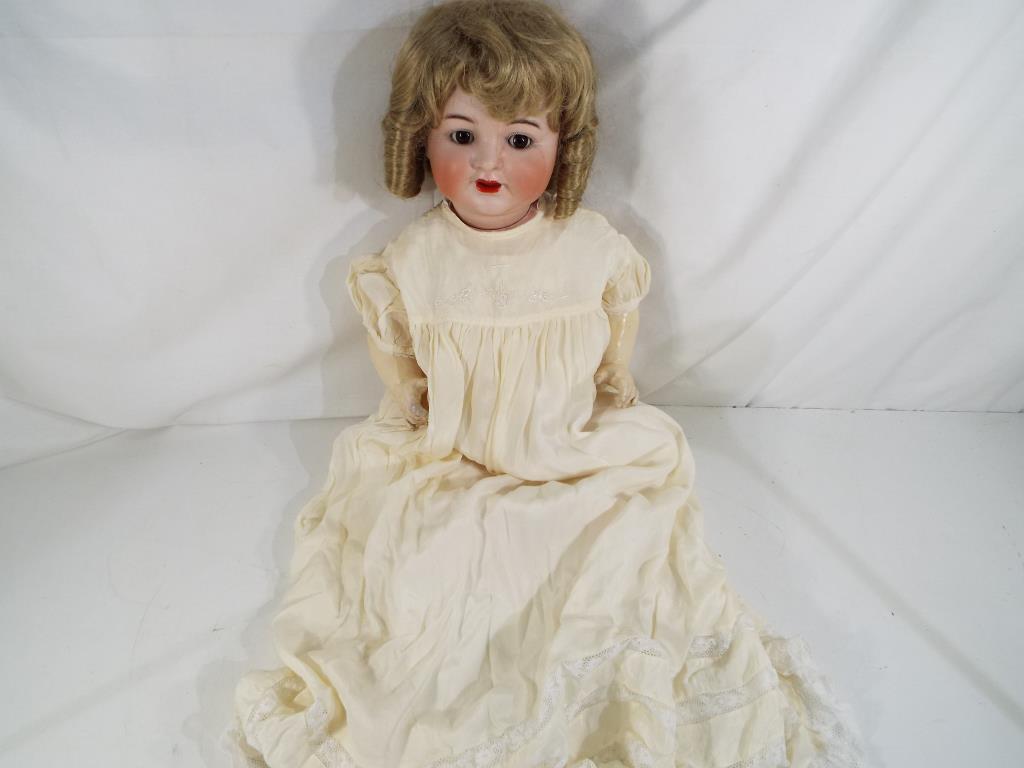 Kammer & Reinhardt - a bisque headed dressed doll by Kammer & Reinhardt with sleeping glass eyes,