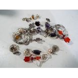 Assorted pairs of silver earrings.