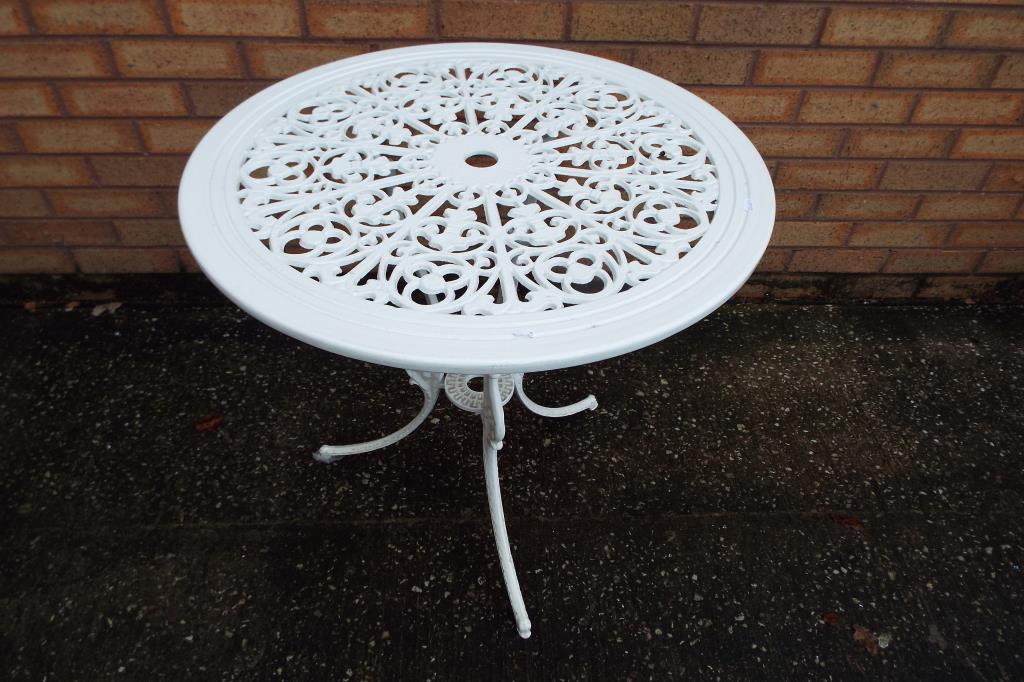 A white painted wrought iron circular garden table,