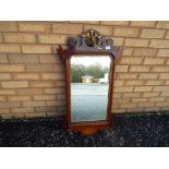 An Edwardian mahogany mirror bevel edged glass surrounded by gilded beading with gilded decoration