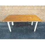 A pine dining table with painted legs approximately 78 cm x 187 cm.
