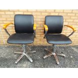 Two retro black wood and chrome finish barber's chairs with swivel movement and pump fitted with