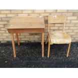 An antique wooden school desk with hinged lid and school chair,