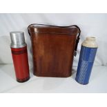 A large scale vintage leather flask holder with three internal flask compartments containing a