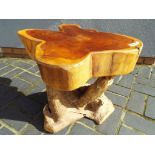 A table made from driftwood with a tree stump top.