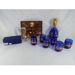 A decorative blue glass drinking set with gilded detailing comprising decanter and six glasses,