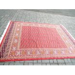 A Bokhara carpet with a red ground,