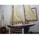 A very large twin masted pond yacht with plastic hull and wooden deck,