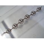 A silver hallmarked bracelet, designed by James C Kerr, comprising six circular links,