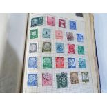 An album containing a collection of UK and world postage stamps,