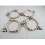 A lot comprising four Asian white metal bangles (possibly silver but untested)