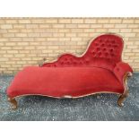 A Victorian oak framed spoon back chaise longue with upholstered finish with button back detailing