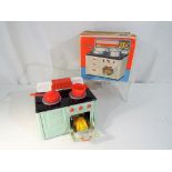 A mid 20th century tin plate toy oven by Fuchs of Western Germany with original pans and roast
