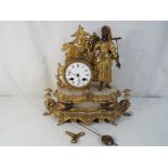 An antique French mantel clock with pendulum and key