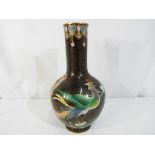 A Chinese cloisonne vase decorated with a phoenix and floral sprays on a black ground,