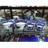 A quantity of blue and white tableware with gilded detail to include plates, cups,