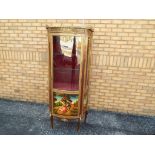 A decorative bow fronted display cabinet with red velvet lined interior,