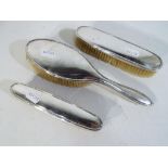 Three German silver backed dressing table brushes marked with crescent and crown mark stamped 830