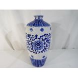 A blue and white Asian vase with panel marks to the base,
