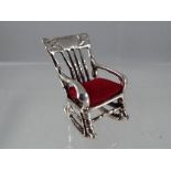 A silver pin cushion in the form of a chair.