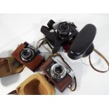 Three cased cameras comprising a Voigtlander, a Cheaha 8 and a Praktica.