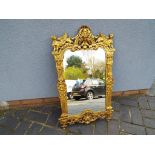 A very good gilt framed mirror ornately decorated throughout the frame,