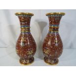 A pair of cloisonne vases of baluster form with scrolling floral and foliate decoration on a burnt