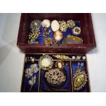A vintage jewellery box with key, containing a quantity of predominantly vintage brooches,