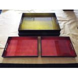 A box containing three papier mache lacquered trays, two small and one large,