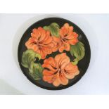 Moorcroft Pottery - a large Moorcroft Pottery plate decorated with hibiscus on a green ground,