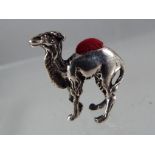 A silver pin cushion in the form of a camel.