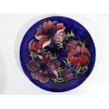 Moorcroft Pottery - a large Moorcroft Pottery plate decorated with clematis on a blue ground,