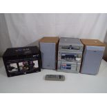 A JVC stereo system with two speakers and a boxed BT 8500 call blocker telephone set.