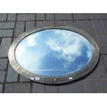An oval framed bevel edged wall mirror,