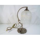 A decorative table lamp with frosted glass shade and hanging droplets,