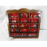 A good quality glazed wood display case containing 30 vintage and modern brooches to include