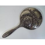 A George V silver hallmarked hand mirror with scrolling floral decoration, Chester assay 1911,