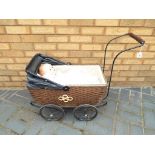Dolls - A wicker and metal dolls pram with a vintage composition doll,