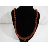 A mixed faceted graduated amber bead necklace with silver clasp,