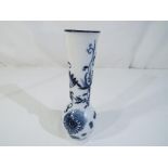 A bud vase, decorated in Blue Onion pattern and stamped cross swords to the base,