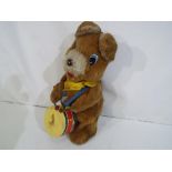 A battery operated mechanical bear playing a drum, marked made in Korea.