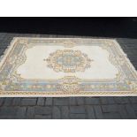 A good quality woolen rug with floral border and floral center piece in cream blue,