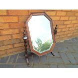 A wood framed bevel edged table top mirror on barley twist supports,