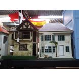 A pair of 1950s dolls houses constructed with carved wood and tin plate (AF) (2)