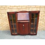 A mahogany bureau bookcase with central bureau section with fitted interior flanked by two glazed