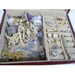 A jewellery box containing a quantity of costume jewellery comprising brooches,